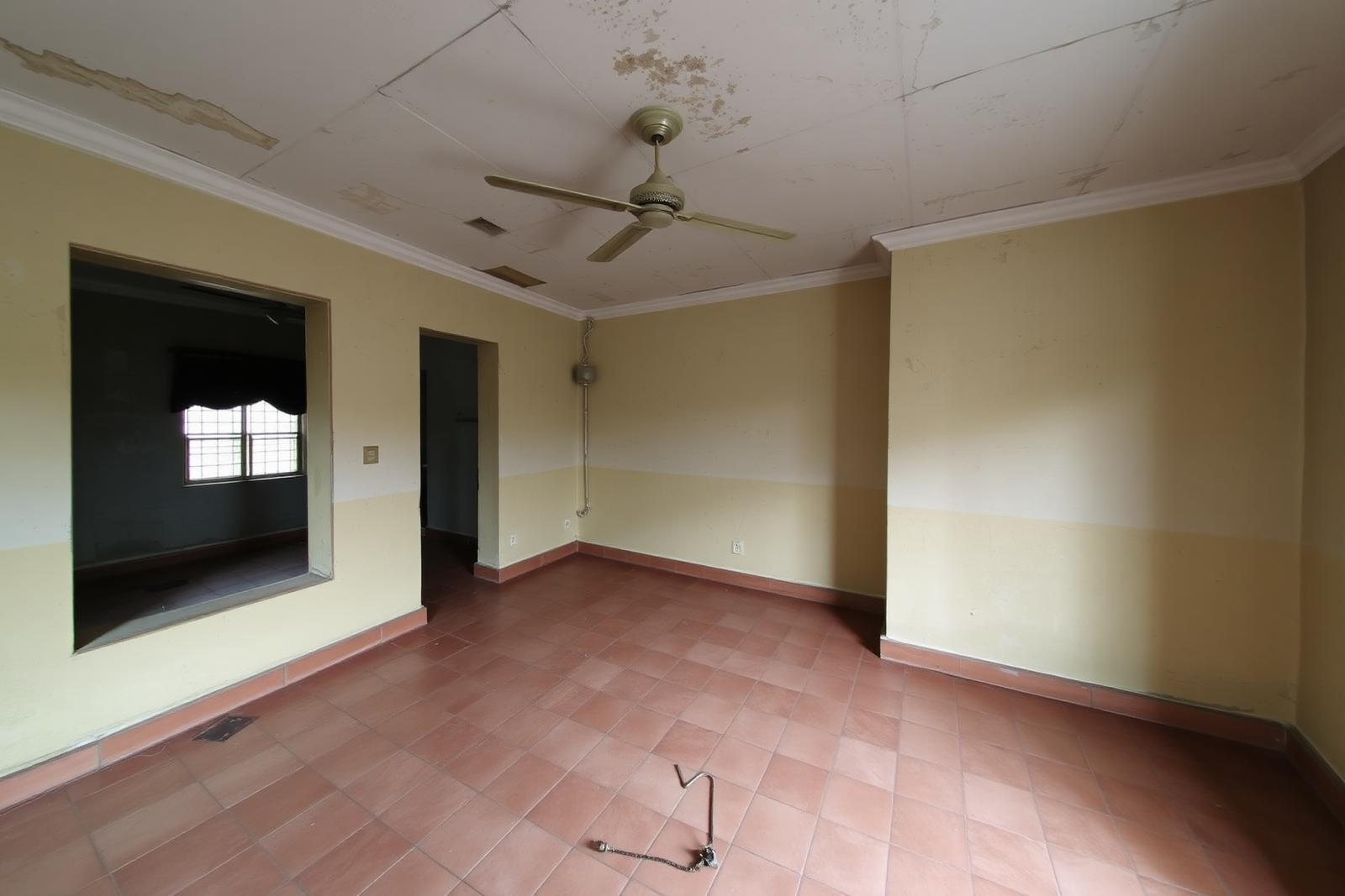 Living area before renovation with worn walls and dated tiles